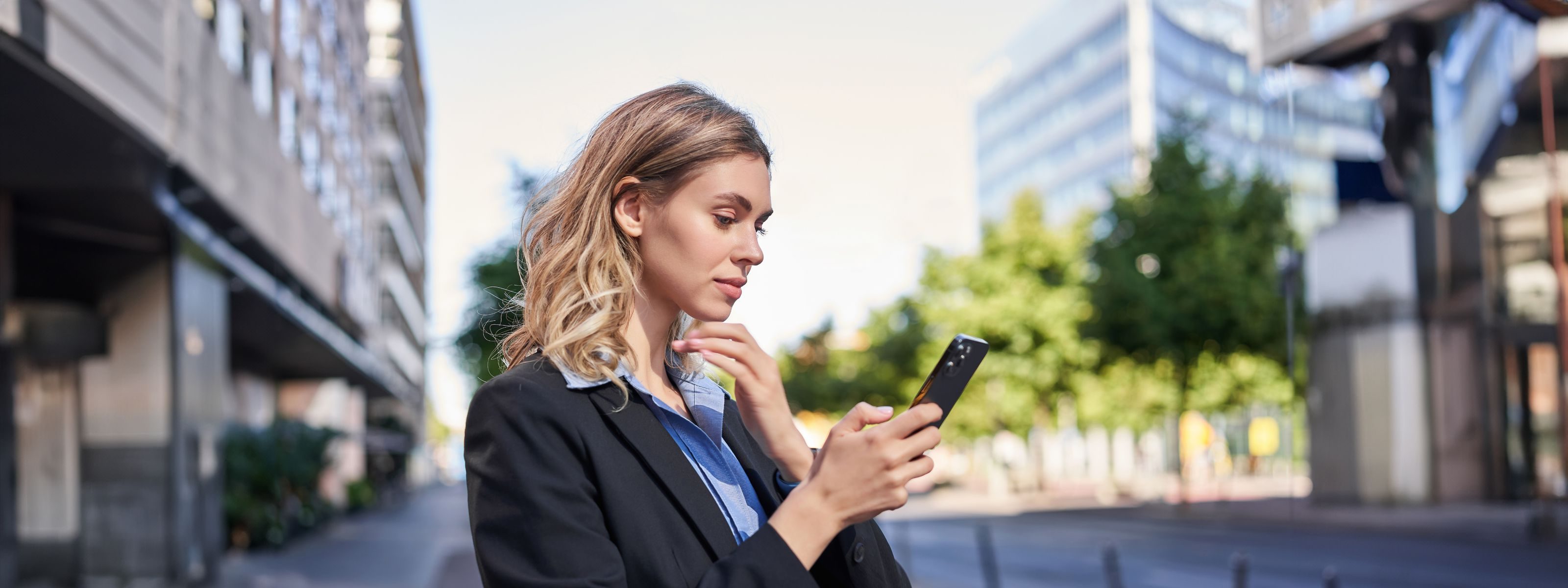 Una professionista al telefono in una via cittadina