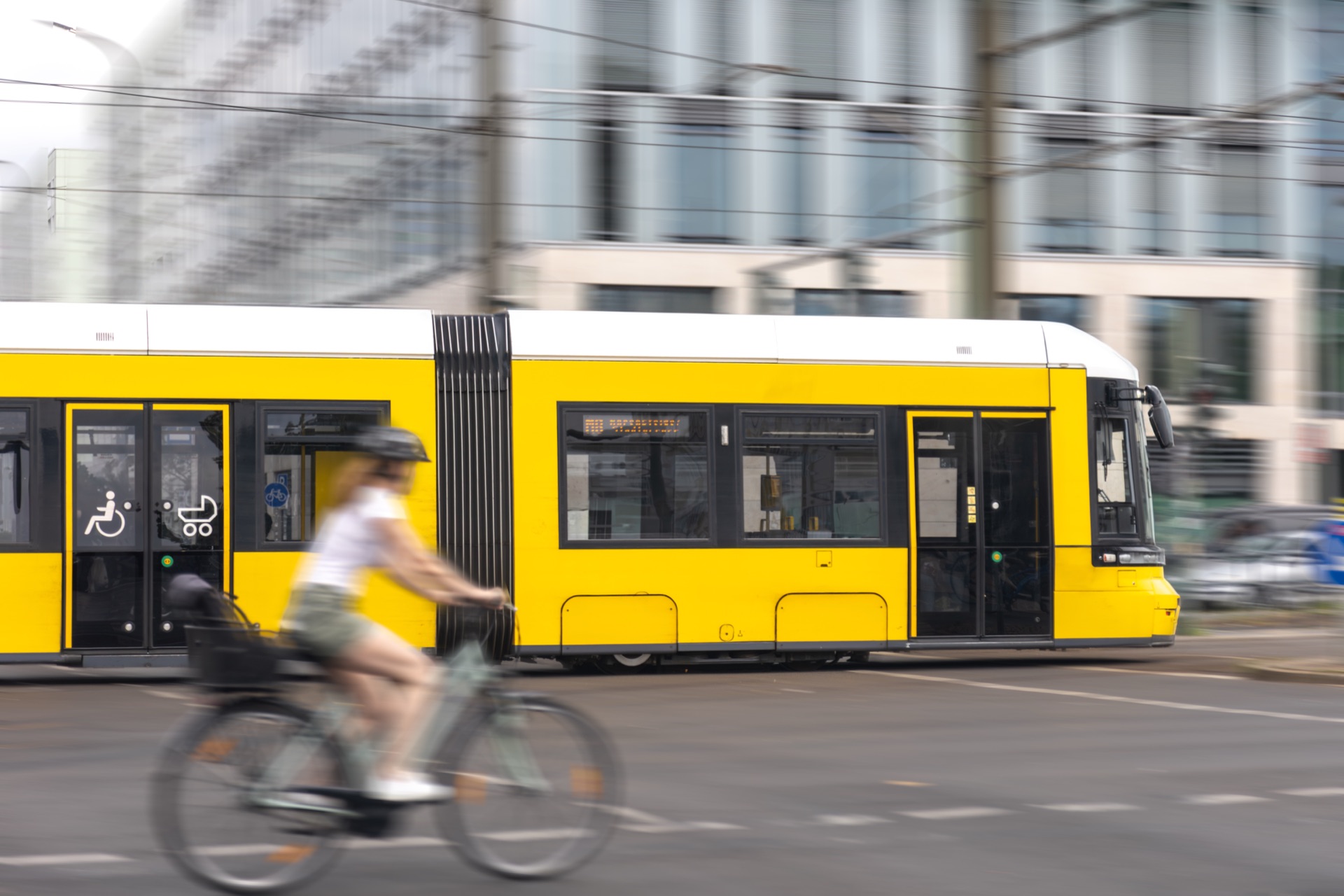 Un ciclista supera un tram in una strada cittadina