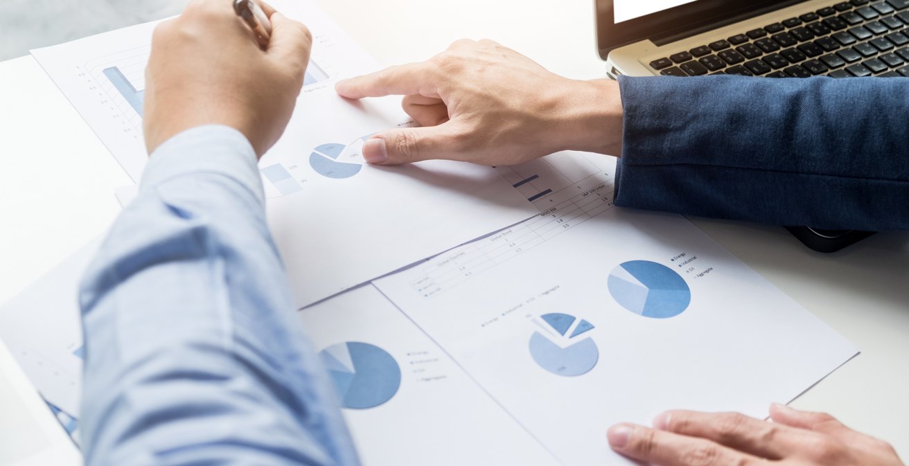 Due persone analizzano grafici stampati su una scrivania