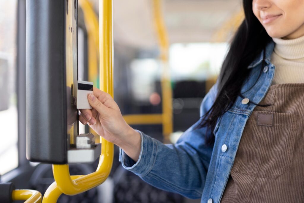 Passeggera che convalida il titolo di viaggio su un autobus